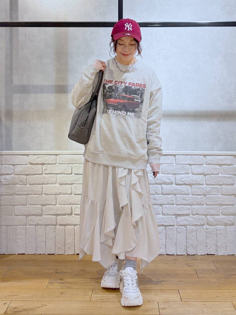 ホワイト系のスニーカー、グレー系のボストンバッグ、ベージュ系のスカートを着用したレディースの冬コーディネートの4枚目の写真