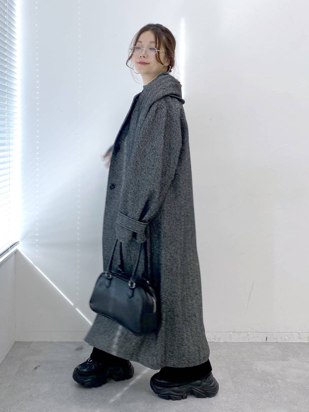 ブラック系のスニーカー、ブラック系のデニムパンツ、グリーン系のニット/セーターを着用したレディースの秋コーディネートの5枚目の写真