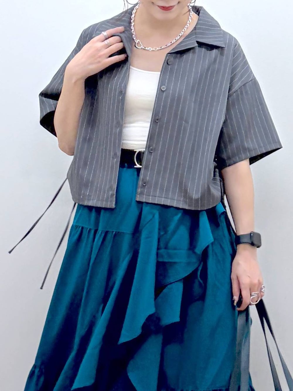 ブルー系のスカート、ブラック系のサンダル、グレー系のシャツ/ブラウスを着用したレディースの夏コーディネートの2枚目の写真