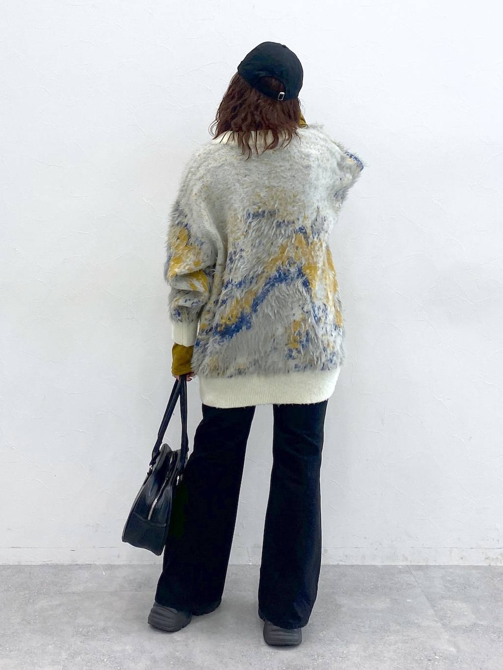 ブラック系のブーツ、ブラック系のボストンバッグ、ホワイト系のカーディガン/ボレロを着用したレディースの秋コーディネートの6枚目の写真