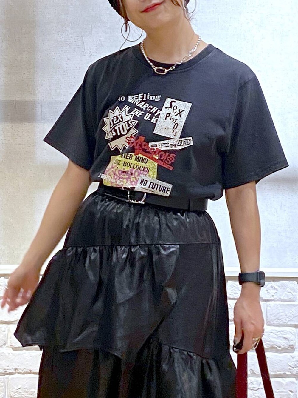 ブラック系のスニーカー、レッド系のショルダーバッグ、ブラック系のスカートを着用したレディースの夏コーディネートの2枚目の写真