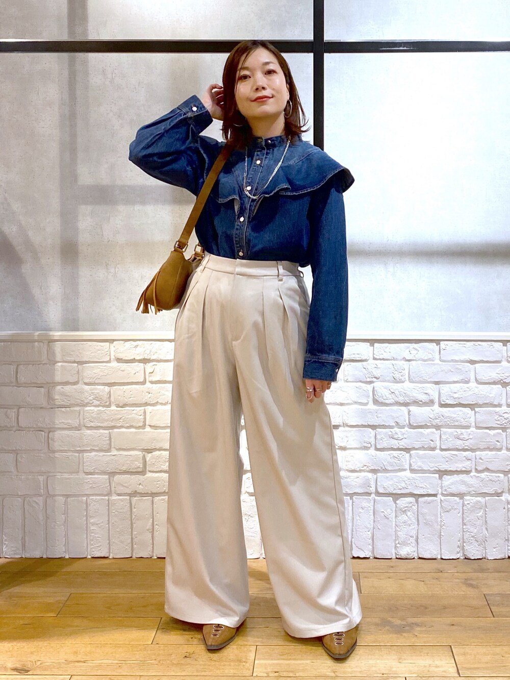 ブルー系のシャツ/ブラウス、ベージュ系のショルダーバッグ、ベージュ系のスラックスを着用したレディースの春コーディネートの9枚目の写真
