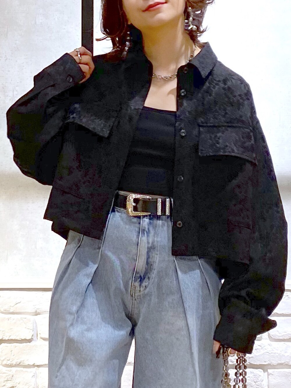 ブラック系のシャツ/ブラウス、ブルー系のデニムパンツ、ブルー系のショルダーバッグを着用したレディースの冬コーディネートの2枚目の写真