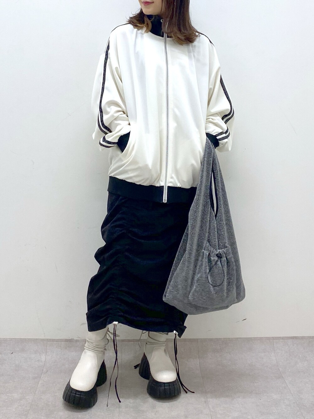 ブラック系のワンピース、ホワイト系のその他アウター、ブラック系のトートバッグを着用したレディースの冬コーディネートの7枚目の写真