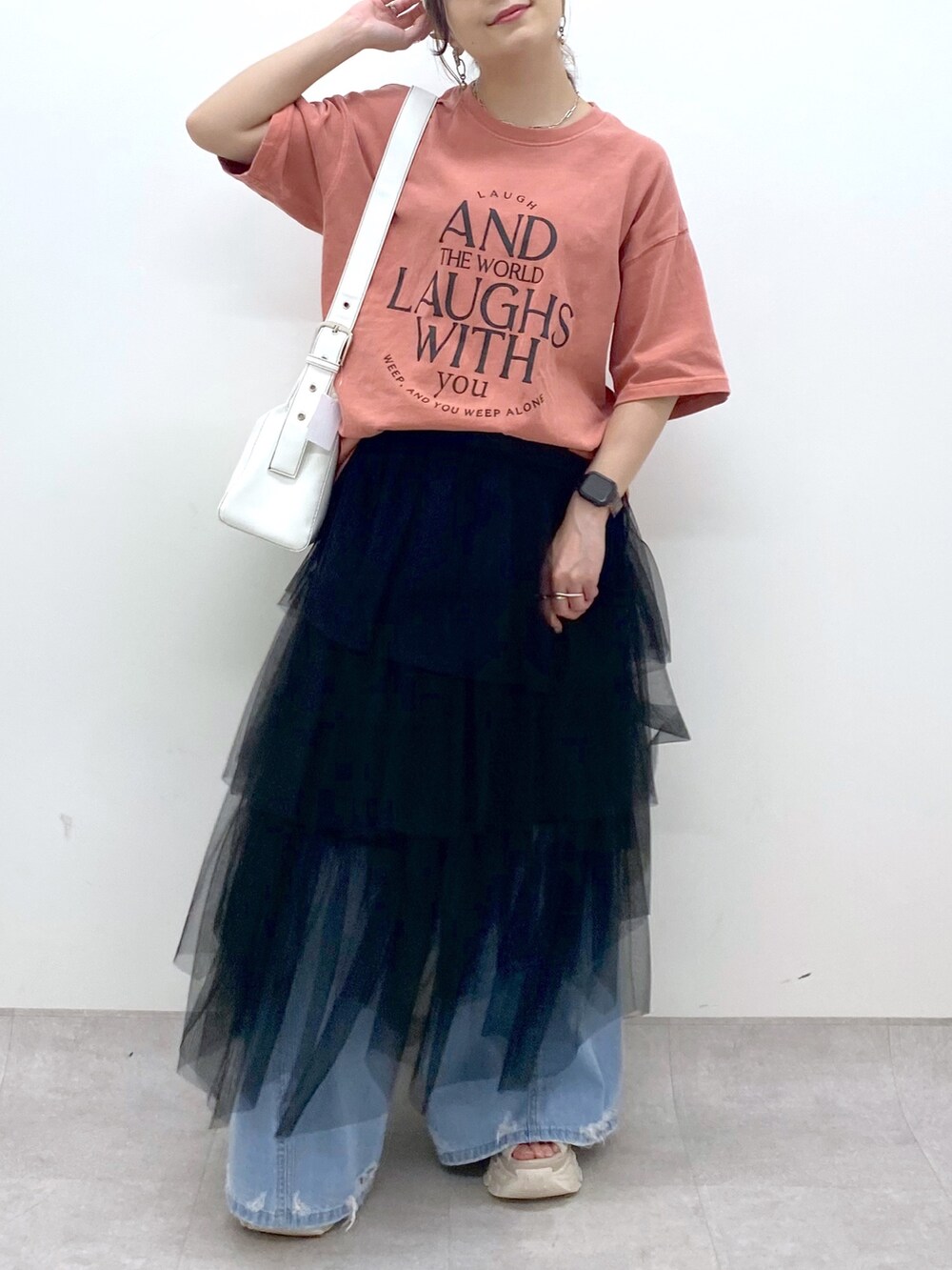 ブルー系のデニムパンツ、オレンジ系のTシャツ/カットソー、ブラック系のスカートを着用したレディースの夏コーディネートの6枚目の写真