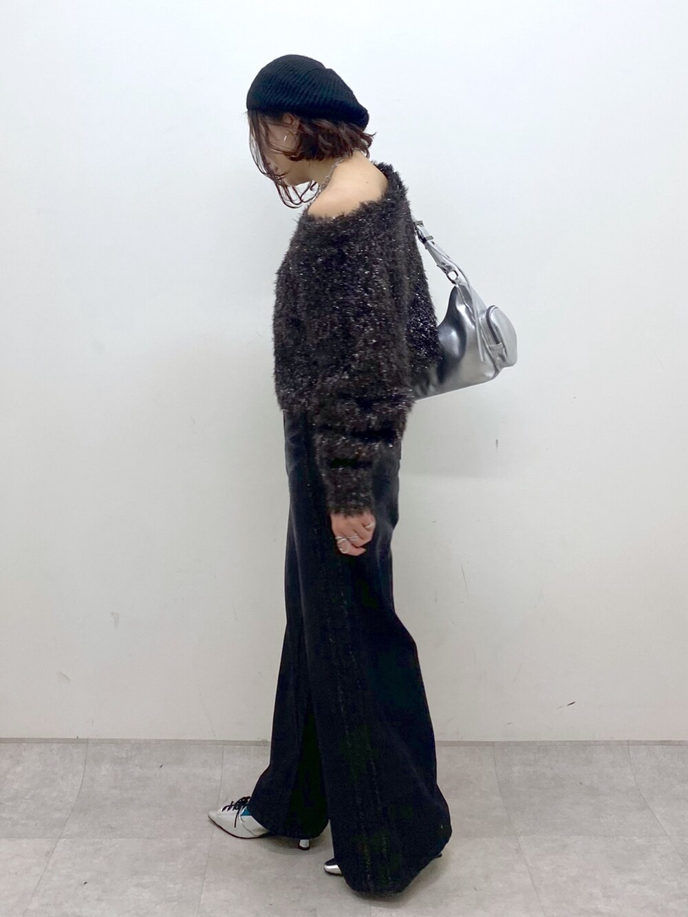 ブラック系のデニムパンツ、シルバー系のパンプス、シルバー系のショルダーバッグを着用したレディースの秋コーディネートの5枚目の写真
