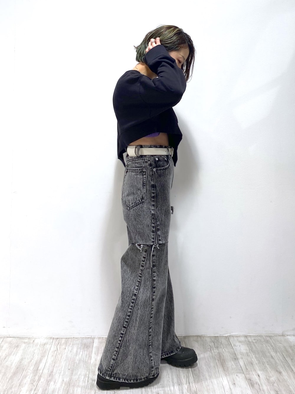 ブラック系のデニムパンツ、ホワイト系のベルト、シルバー系のリングを着用したレディースの冬コーディネートの2枚目の写真