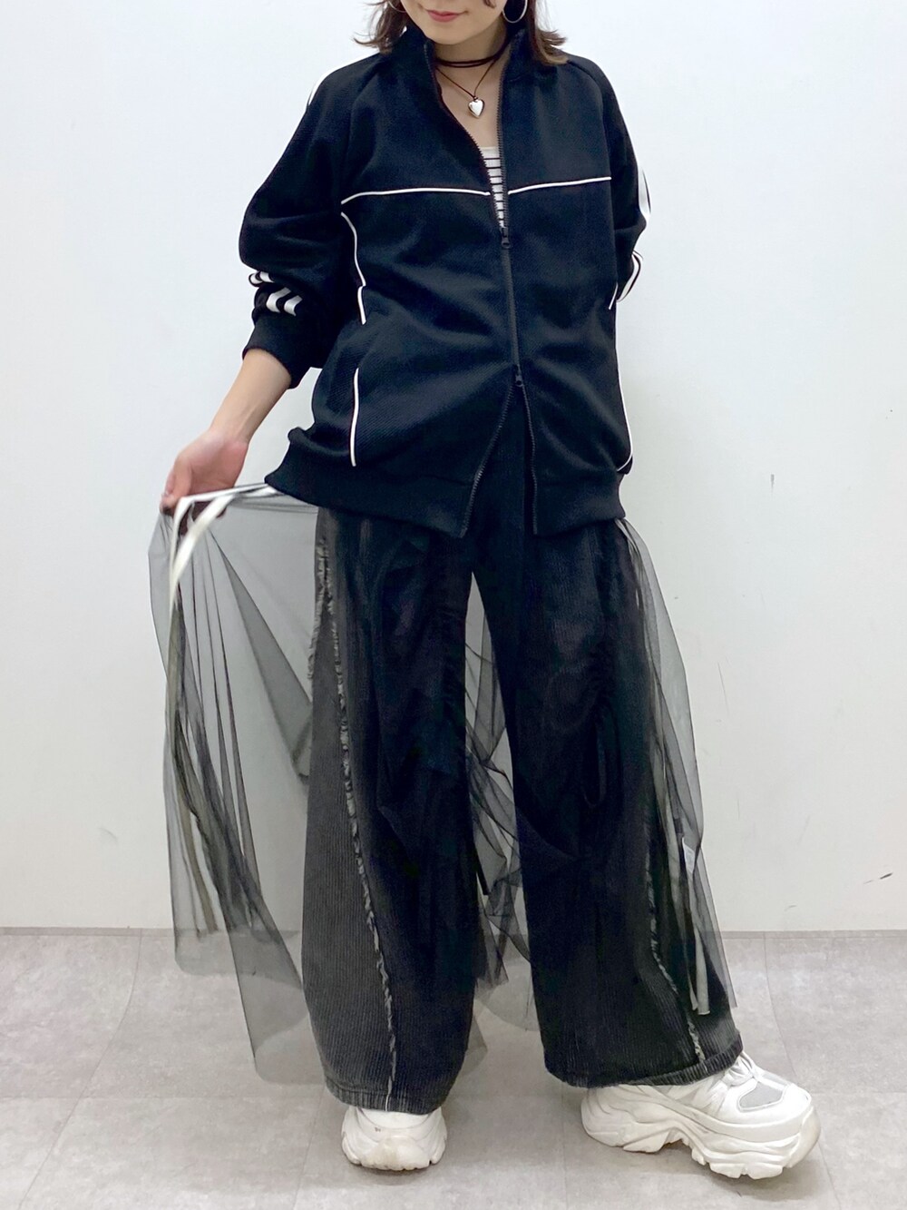 ブラック系のデニムパンツ、ホワイト系のスニーカー、ブラック系のジャージを着用したレディースの夏コーディネートの3枚目の写真