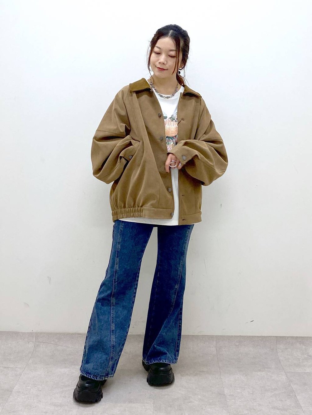 ブラック系のスニーカー、ブルー系のデニムパンツ、ブラウン系のショルダーバッグを着用したレディースの秋コーディネートの8枚目の写真