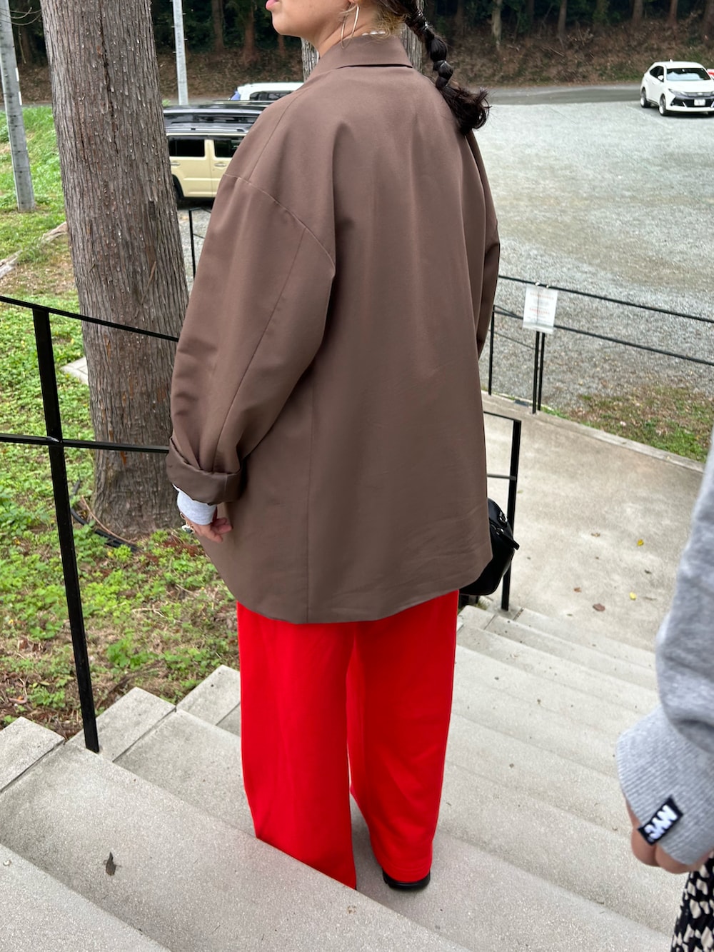 ブラウン系のテーラードジャケット、グリーン系のキャップ、ベージュ系のネックレスを着用したレディースの秋コーディネートの2枚目の写真