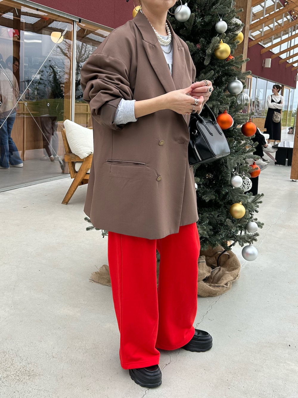 ブラウン系のテーラードジャケット、グリーン系のキャップ、ベージュ系のネックレスを着用したレディースの秋コーディネートの3枚目の写真