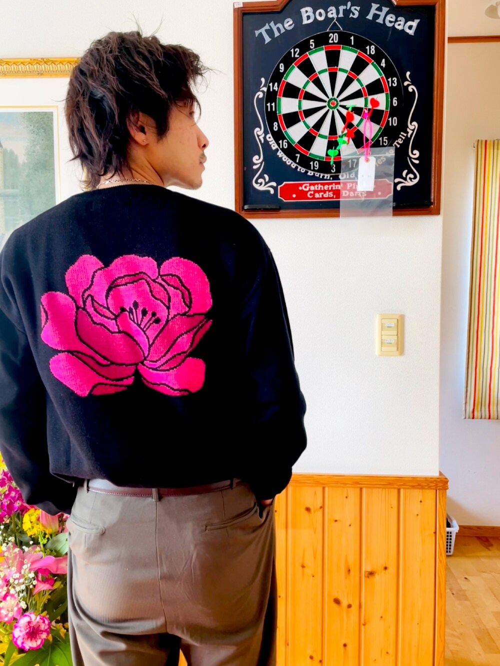 ブラック系のニット/セーター、グリーン系のスラックスを着用したメンズの春コーディネートの2枚目の写真