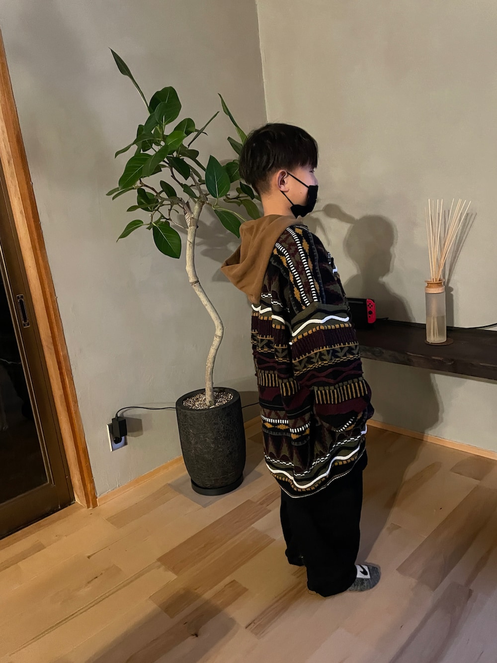 ブラック系のニット/セーター、ブラック系のその他パンツ、ブラウン系のパーカーを着用したキッズの冬コーディネートの2枚目の写真