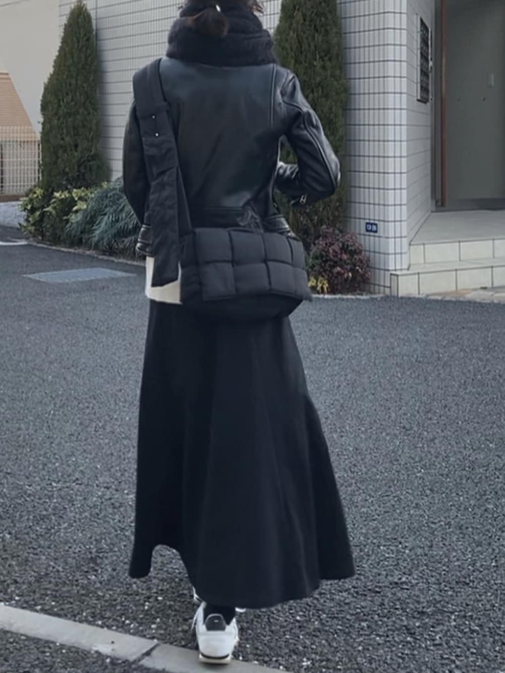 ブラック系のライダースジャケット、ブラック系のバッグ、ブラック系のスカートを着用したレディースの春コーディネートの3枚目の写真