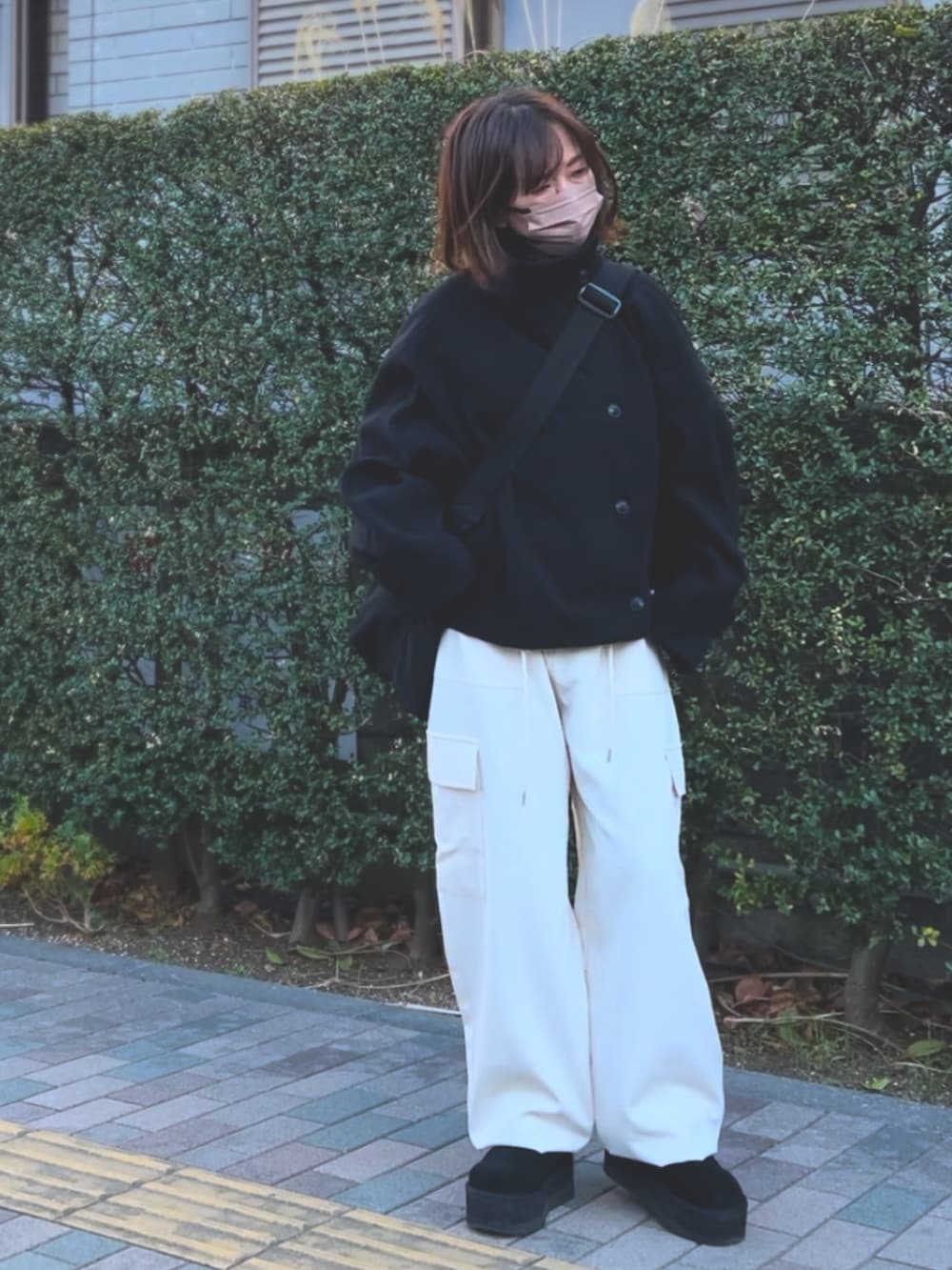 ブラック系のその他アウター、ホワイト系のカーゴパンツ、ブラック系のショルダーバッグを着用したレディースの冬コーディネートの2枚目の写真
