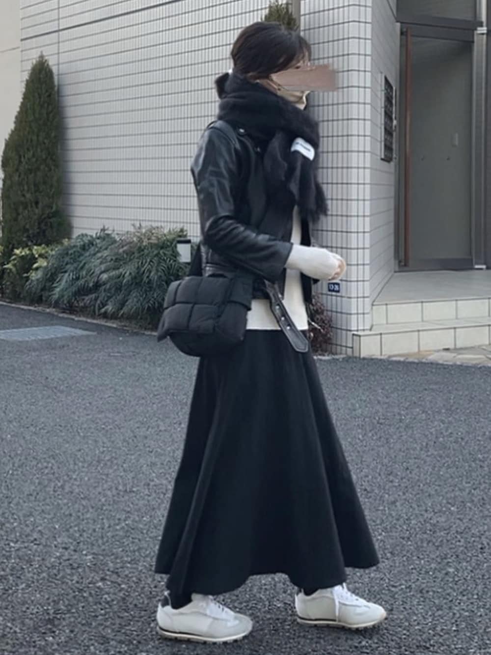 ブラック系のライダースジャケット、ブラック系のバッグ、ブラック系のスカートを着用したレディースの春コーディネートの2枚目の写真