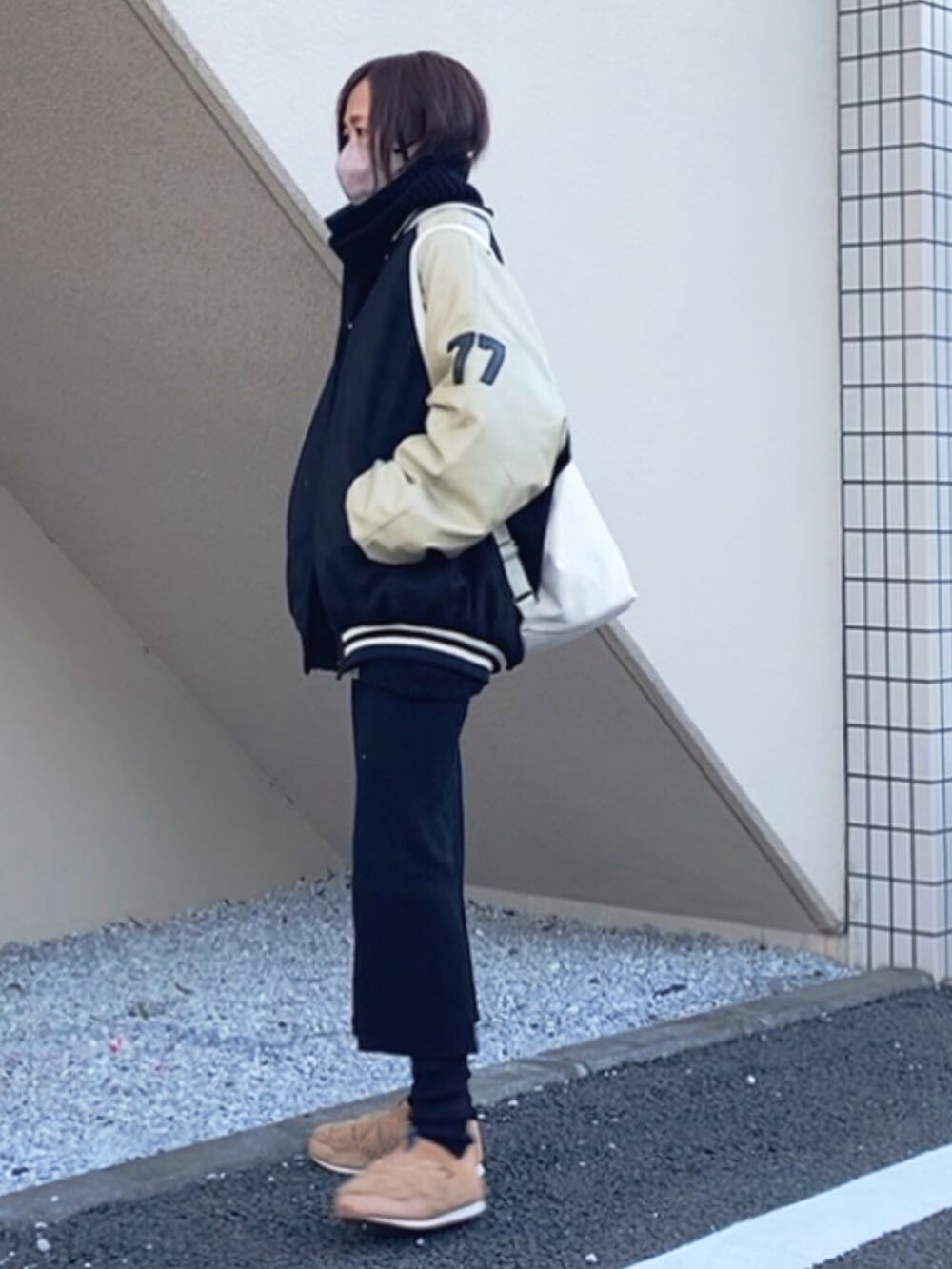 ブラック系のスタジャン、ホワイト系のバックパック/リュック、ブラック系のスカートを着用したレディースの冬コーディネートの2枚目の写真