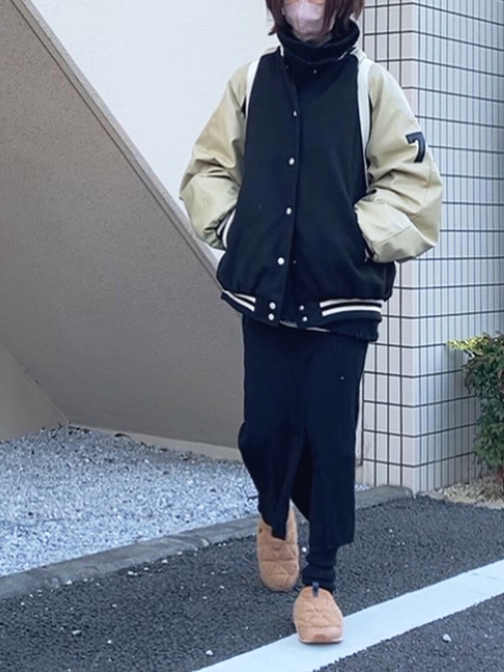 ブラック系のスタジャン、ホワイト系のバックパック/リュック、ブラック系のスカートを着用したレディースの冬コーディネートの3枚目の写真