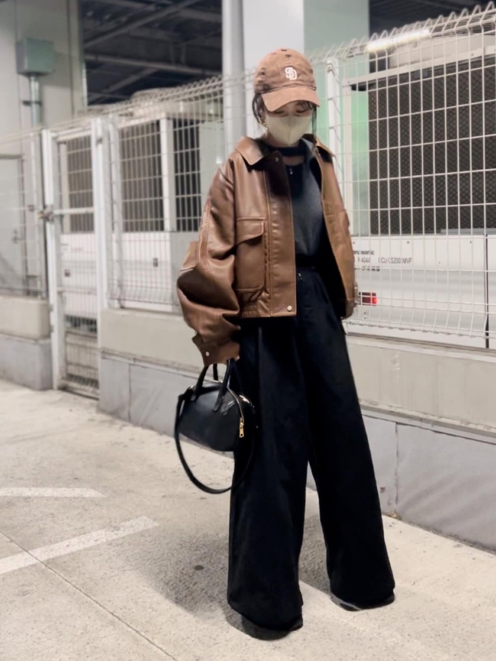 ブラウン系のブルゾン、ブラック系のボストンバッグ、ブラック系のその他パンツを着用したレディースの秋コーディネートの2枚目の写真