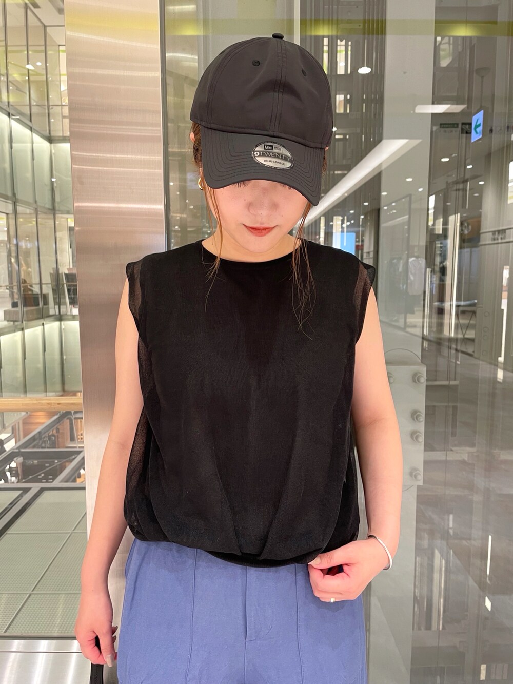 ブラック系のニット/セーター、ブルー系のその他パンツ、ブラック系のキャップを着用したレディースの夏コーディネートの2枚目の写真