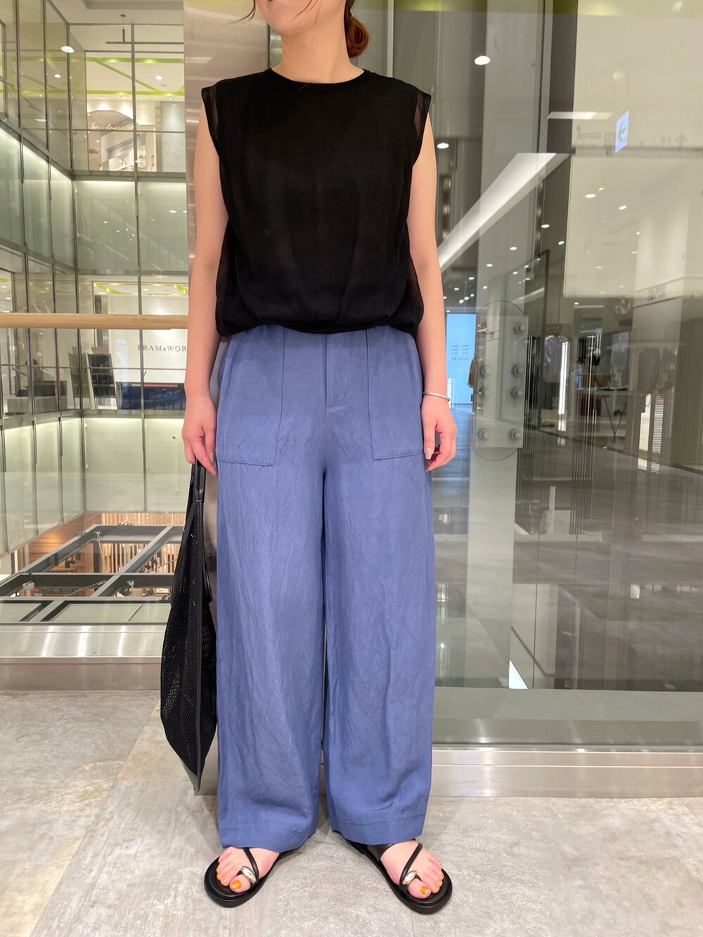 ブラック系のニット/セーター、ブルー系のその他パンツ、ブラック系のキャップを着用したレディースの夏コーディネートの3枚目の写真