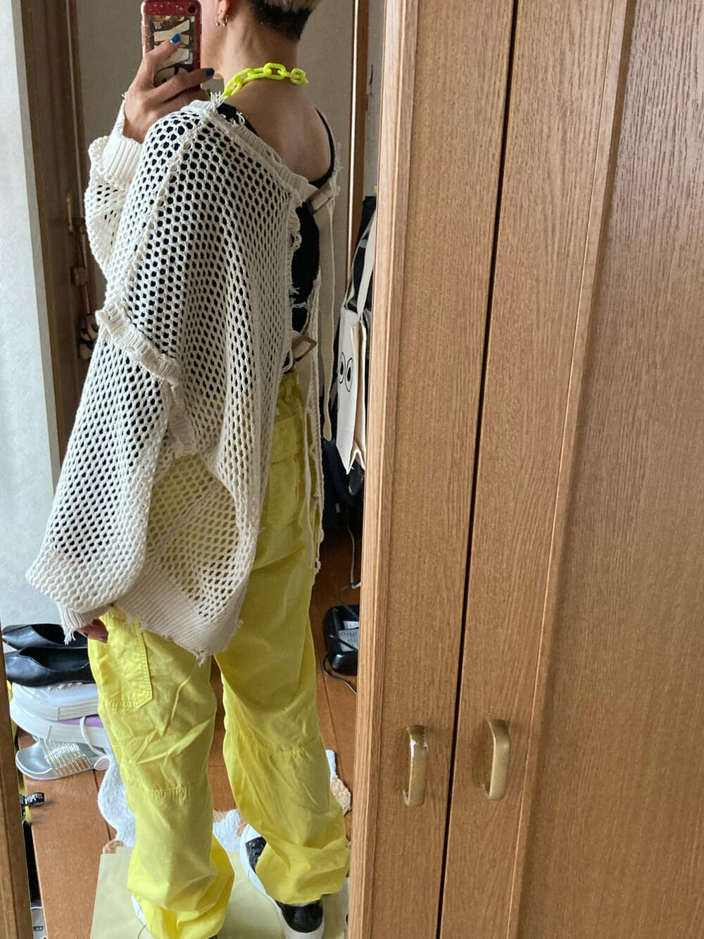 ホワイト系のカーディガン/ボレロ、イエロー系のカーゴパンツ、イエロー系のネックレスを着用したレディースの春コーディネートの2枚目の写真