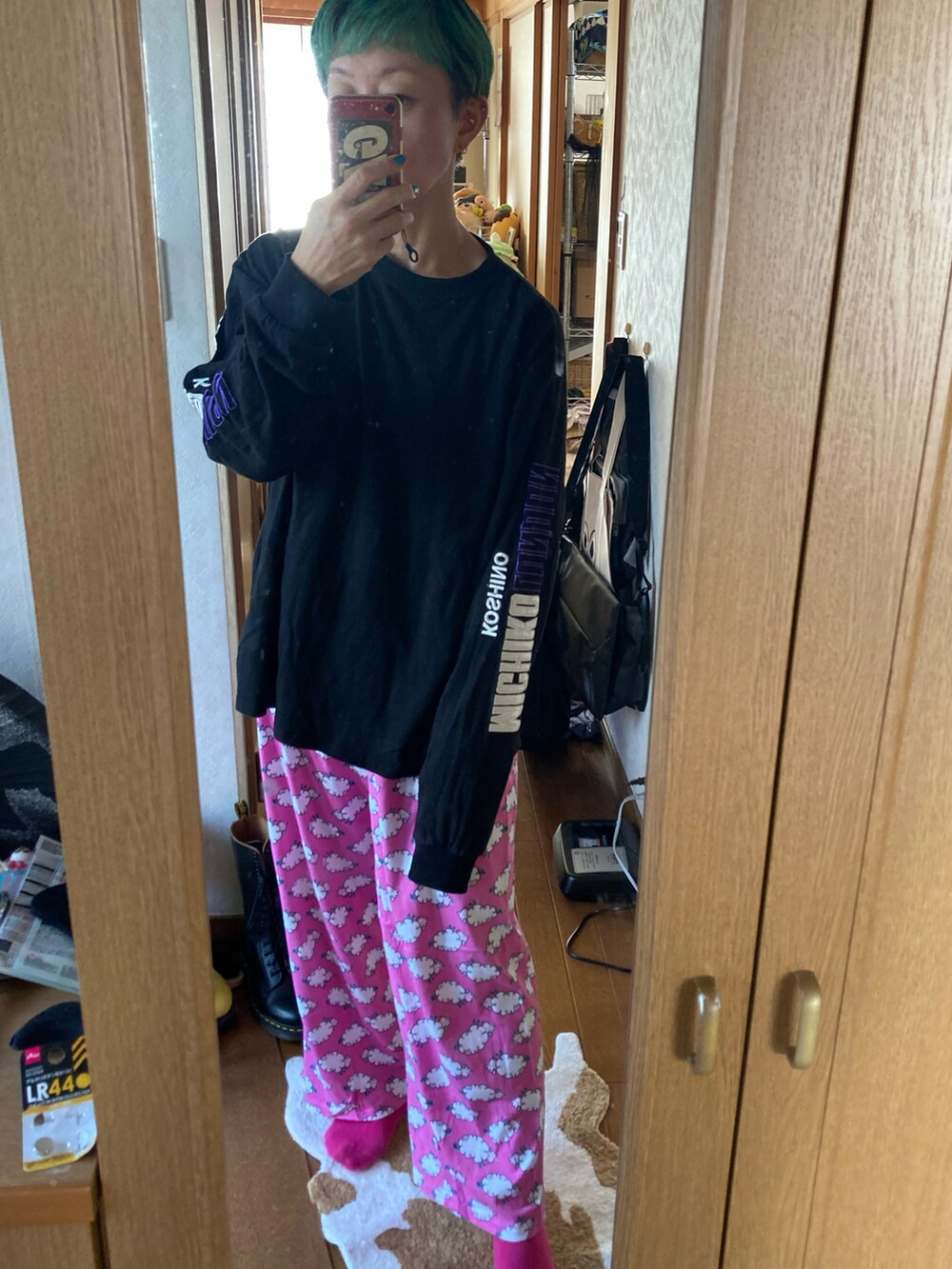 レッド系のニット/セーター、ブラック系のパンツを着用したレディースの秋コーディネートの2枚目の写真