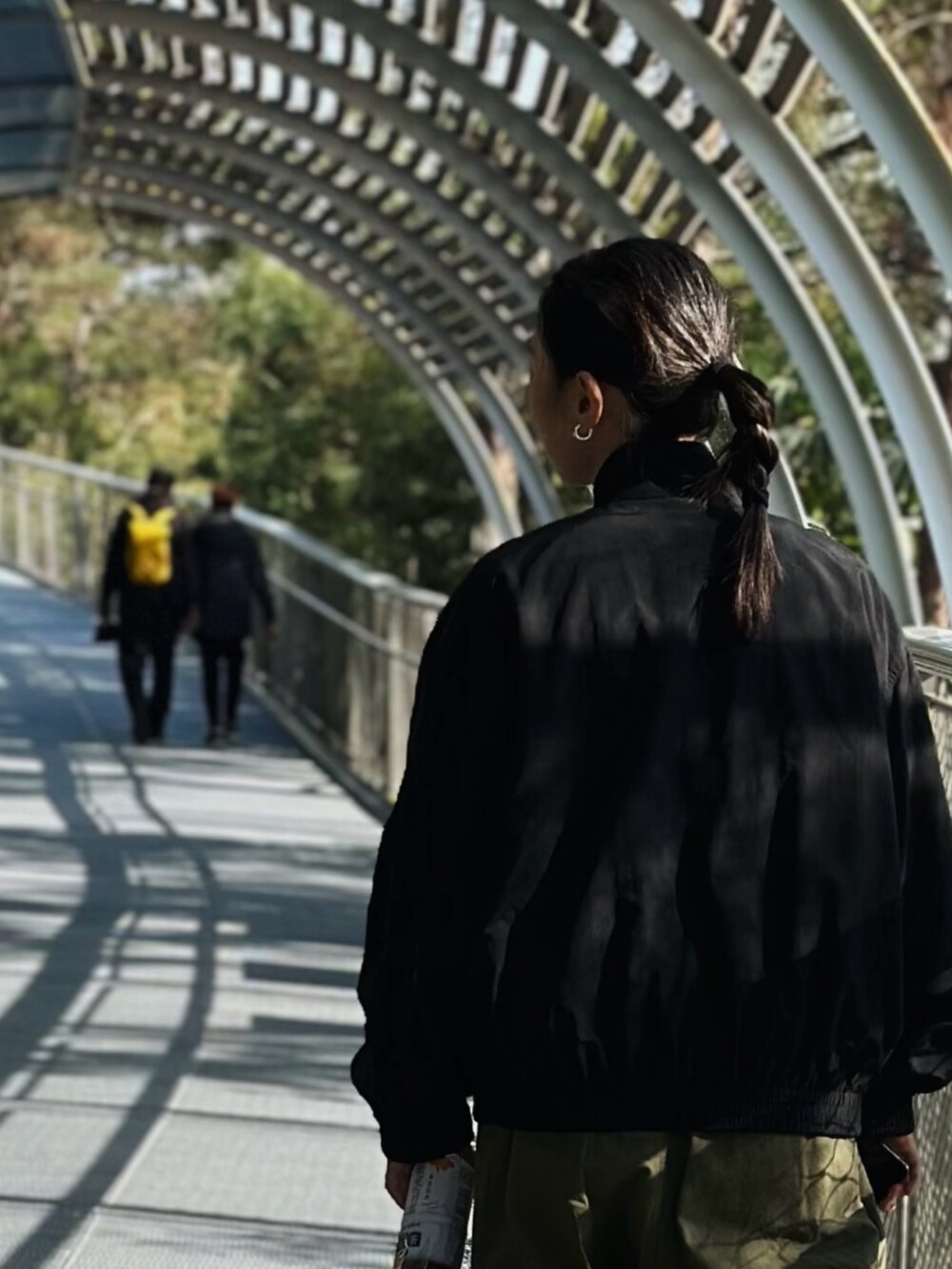 ブラック系のマウンテンパーカー、グリーン系のスニーカーを着用したレディースの冬コーディネートの2枚目の写真