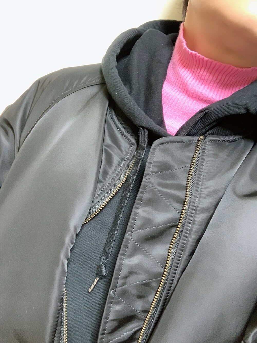ブラック系のMA-1、ピンク系のニット/セーター、ブラック系のスカートを着用したレディースの春コーディネートの2枚目の写真