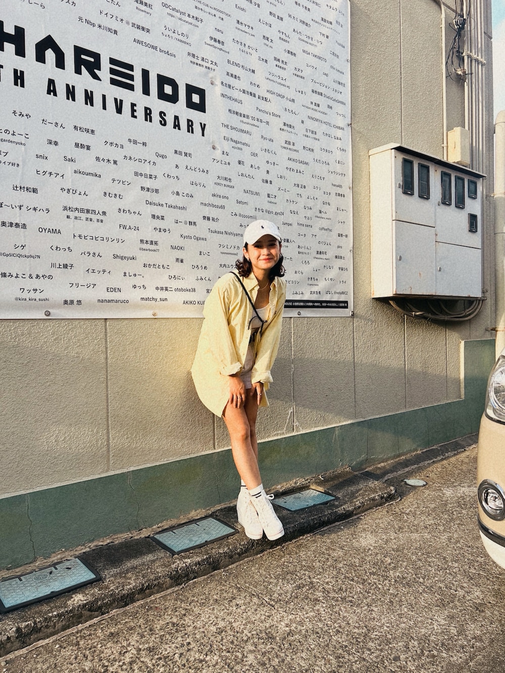 イエロー系のシャツ/ブラウス、ホワイト系のパンツ、ホワイト系のキャップを着用したレディースの秋コーディネートの2枚目の写真