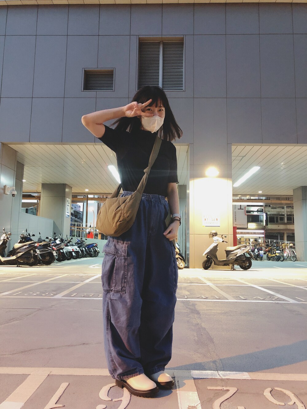 ブルー系のデニムパンツ、ブラック系のトップス、ベージュ系のシューズを着用したレディースの秋コーディネートの2枚目の写真