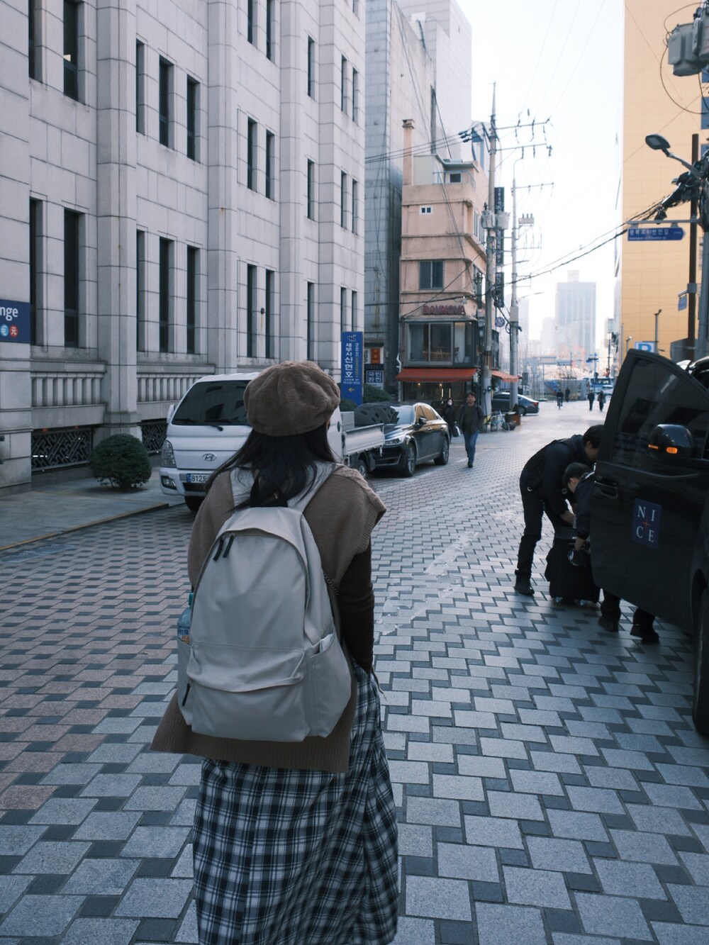 ベージュ系のTシャツ/カットソー、ブルー系のスカート、ホワイト系のスニーカーを着用したレディースの冬コーディネートの5枚目の写真