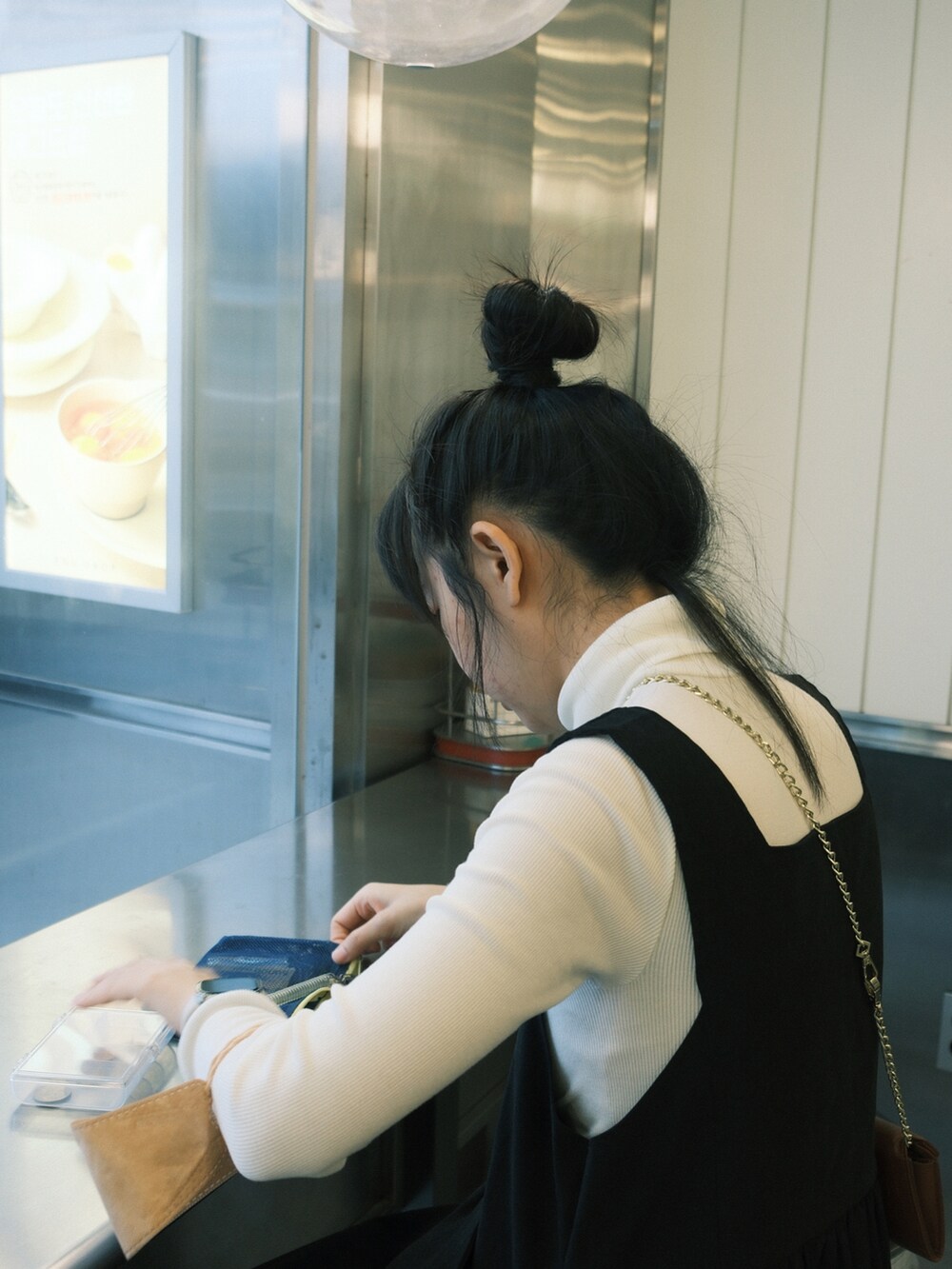 ブラック系のワンピース/ドレス、ホワイト系のスニーカー、ホワイト系のトップスを着用したレディースの冬コーディネートの2枚目の写真