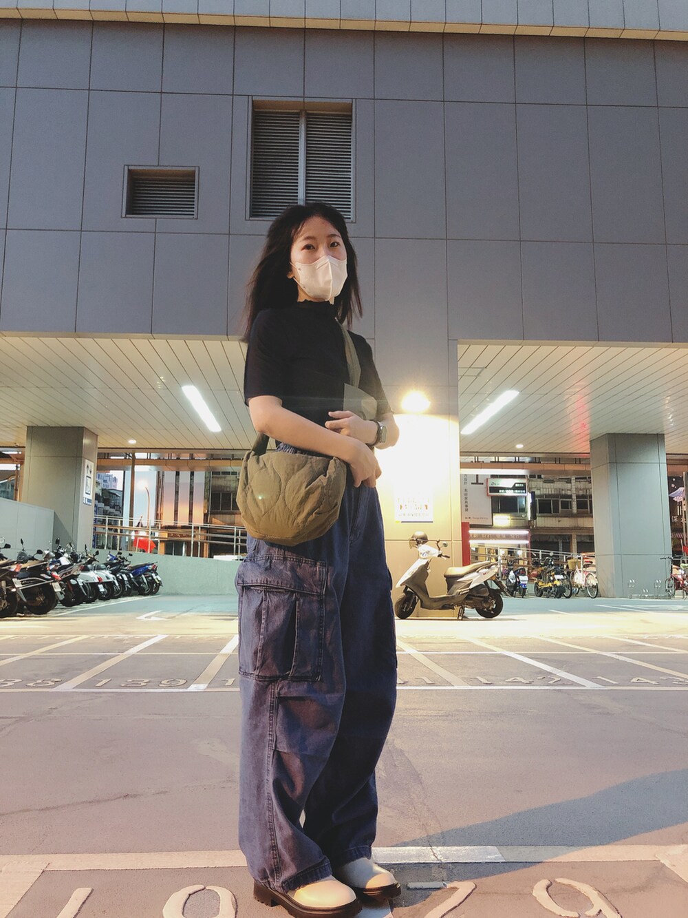 ブルー系のデニムパンツ、ブラック系のトップス、ベージュ系のシューズを着用したレディースの秋コーディネートの3枚目の写真