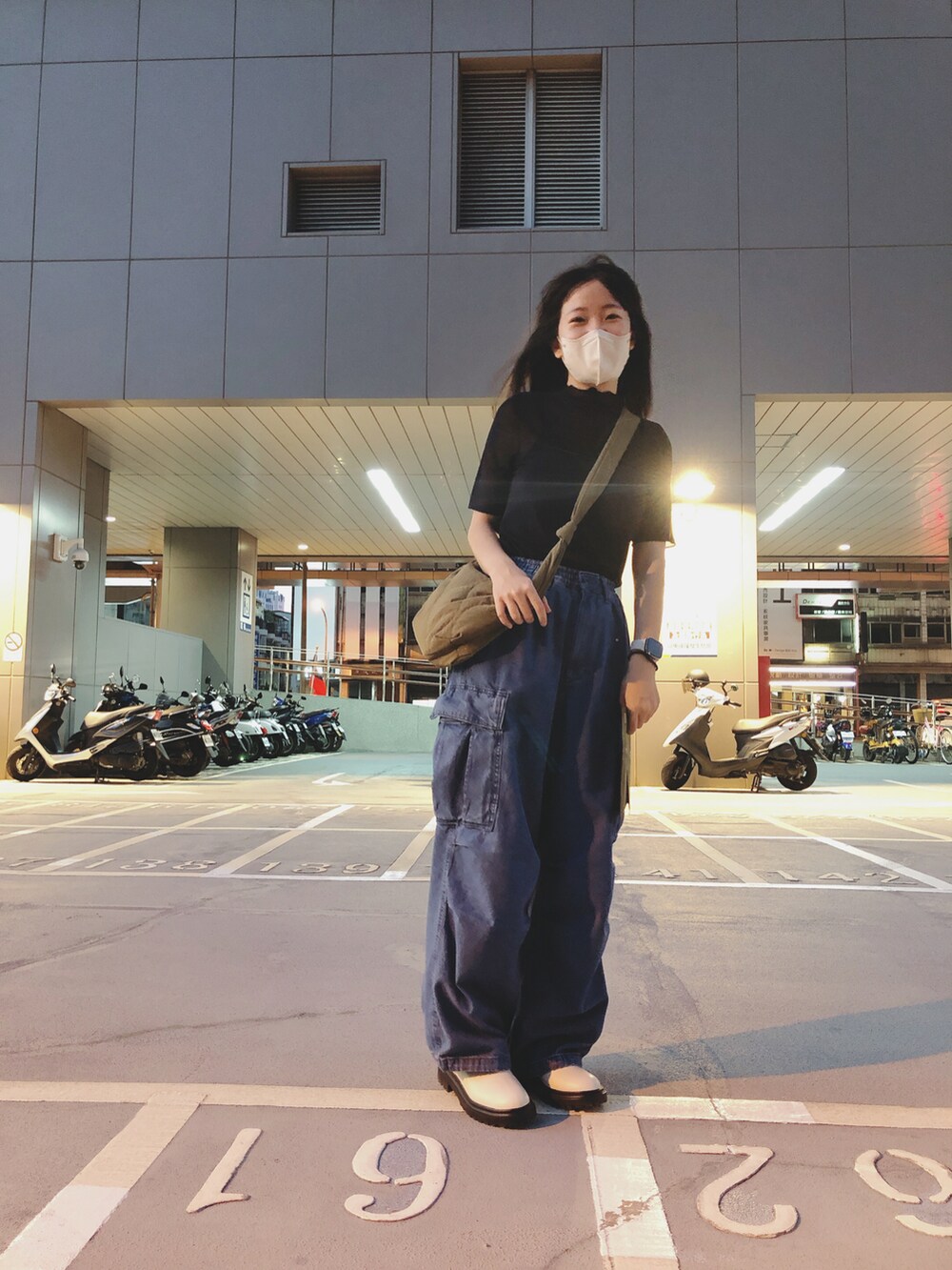 ブルー系のデニムパンツ、ブラック系のトップス、ベージュ系のシューズを着用したレディースの秋コーディネートの4枚目の写真