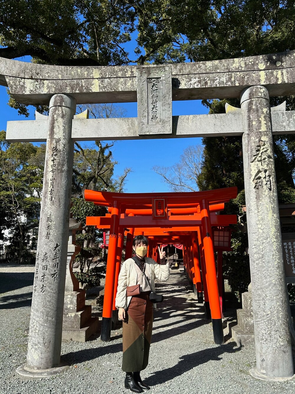 ブラウン系のスカート、ブラック系のシューズ、グリーン系のジャケット/アウターを着用したレディースの春コーディネートの4枚目の写真