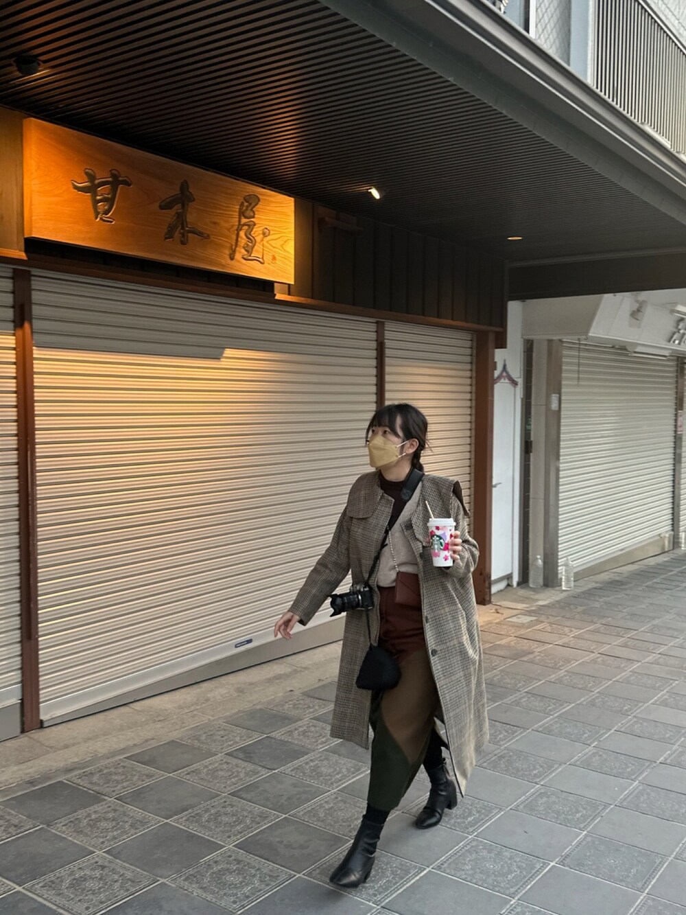 ブラウン系のスカート、ブラック系のシューズ、グリーン系のジャケット/アウターを着用したレディースの春コーディネートの5枚目の写真