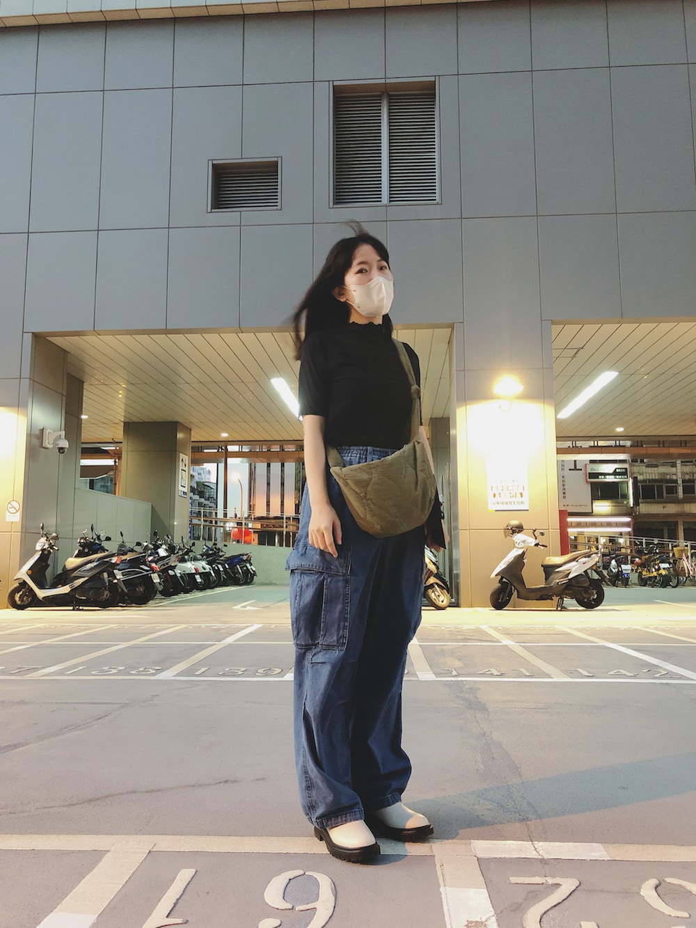 ブルー系のデニムパンツ、ブラック系のトップス、ベージュ系のシューズを着用したレディースの秋コーディネートの5枚目の写真