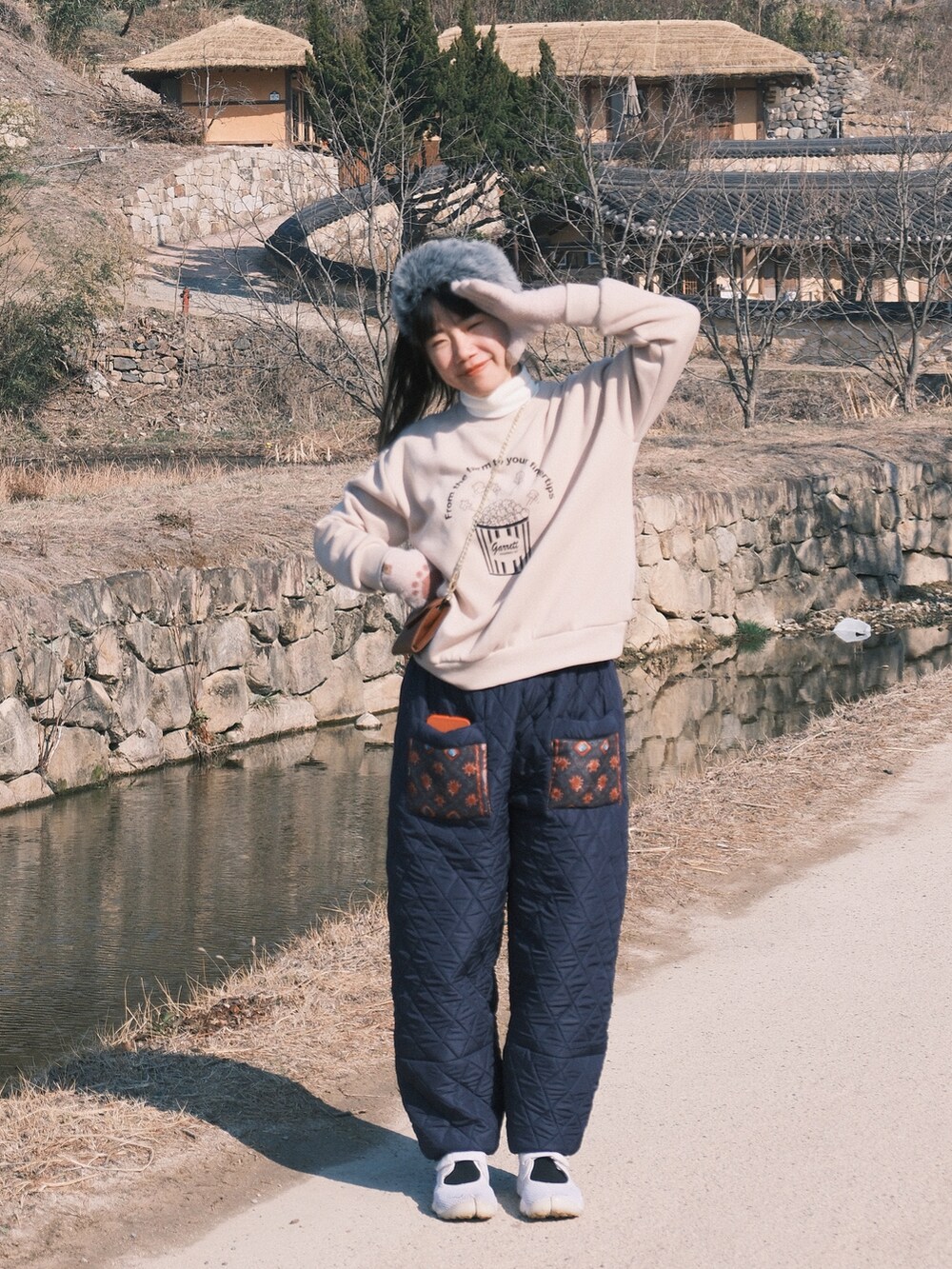 ホワイト系のスニーカーを着用したレディースの冬コーディネートの2枚目の写真