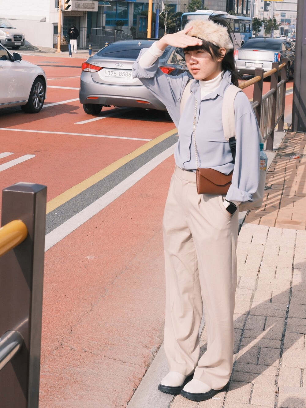 ベージュ系のバックパック/リュック、ホワイト系のトップス、ベージュ系のパンツを着用したレディースの冬コーディネートの4枚目の写真