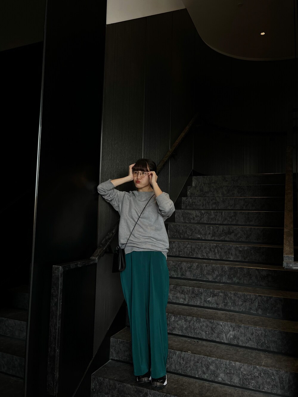 グレー系のスウェット、ブラック系のショルダーバッグ、グリーン系のその他パンツを着用したレディースの春コーディネートの2枚目の写真