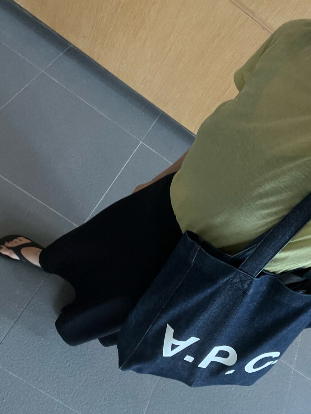 ブルー系のトートバッグ、ブラック系のスカート、ブラック系のサンダルを着用したレディースの夏コーディネートの3枚目の写真