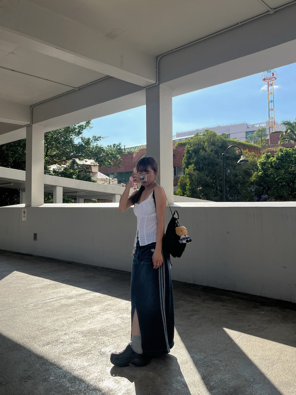 ホワイト系のトップス、ブルー系のデニムスカート、ブラック系のサンダルを着用したレディースの秋コーディネートの2枚目の写真