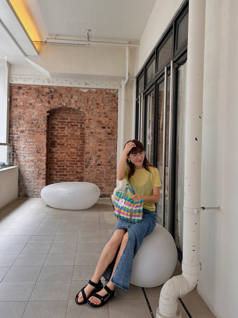 グリーン系のTシャツ/カットソー、ブルー系のデニムスカート、ブラック系のサンダルを着用したレディースの秋コーディネートの2枚目の写真