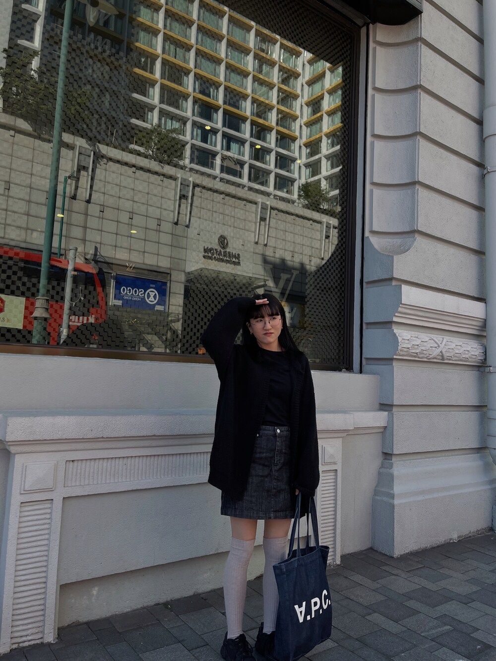 ブラック系のTシャツ/カットソー、ブルー系のデニムスカート、ブラック系のニット/セーターを着用したレディースの冬コーディネートの2枚目の写真