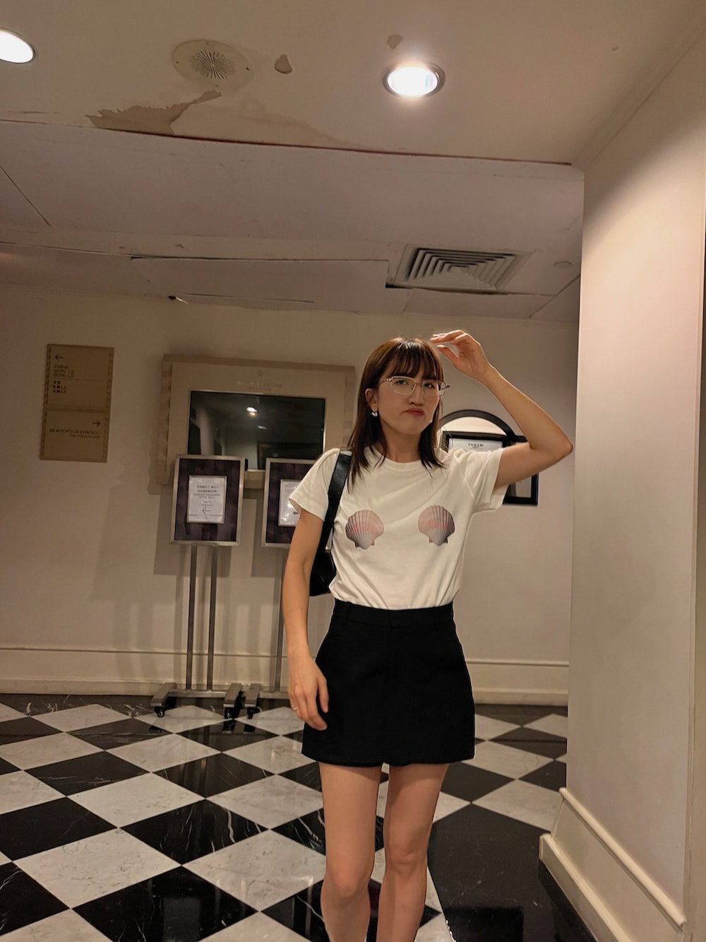 ホワイト系のTシャツ/カットソー、ブラック系のシューズ、ブラック系のスカートを着用したレディースの夏コーディネートの2枚目の写真