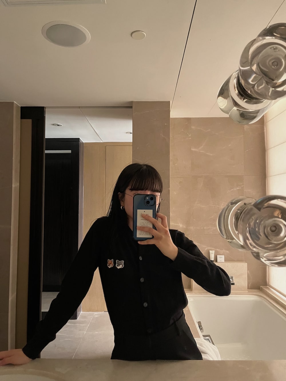 ブラック系のカーディガン/ボレロ、ブラック系のスカートを着用したレディースの冬コーディネートの2枚目の写真