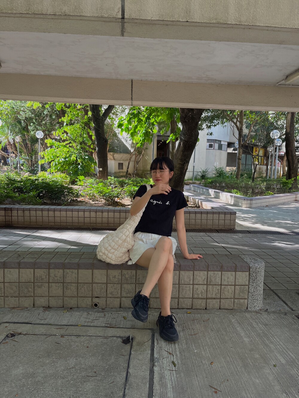 ブラック系のTシャツ/カットソー、ホワイト系のパンツ、ホワイト系のバッグを着用したレディースの夏コーディネートの2枚目の写真