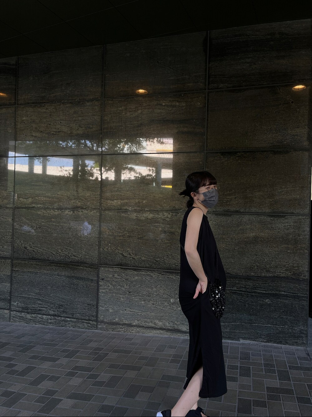 ブラック系のワンピース/ドレス、ブラック系のショルダーバッグ、ブラック系のスニーカーを着用したレディースの春コーディネートの2枚目の写真