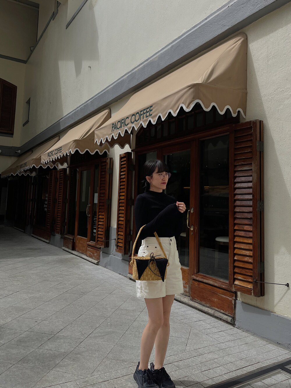 ブラック系のニット/セーター、ホワイト系のデニムパンツ、その他のかごバッグを着用したレディースの冬コーディネートの2枚目の写真